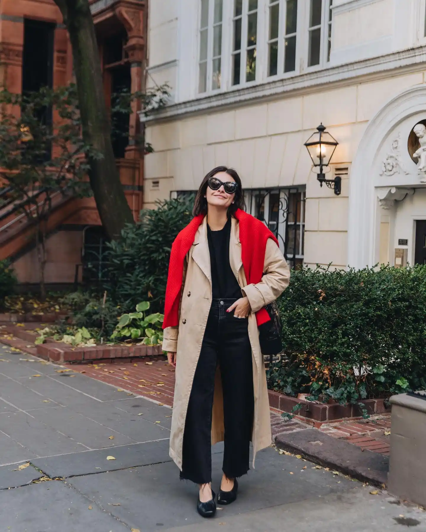 Red Sweater Layer Over a Trench Coat Adds a Bold Fall Accent
