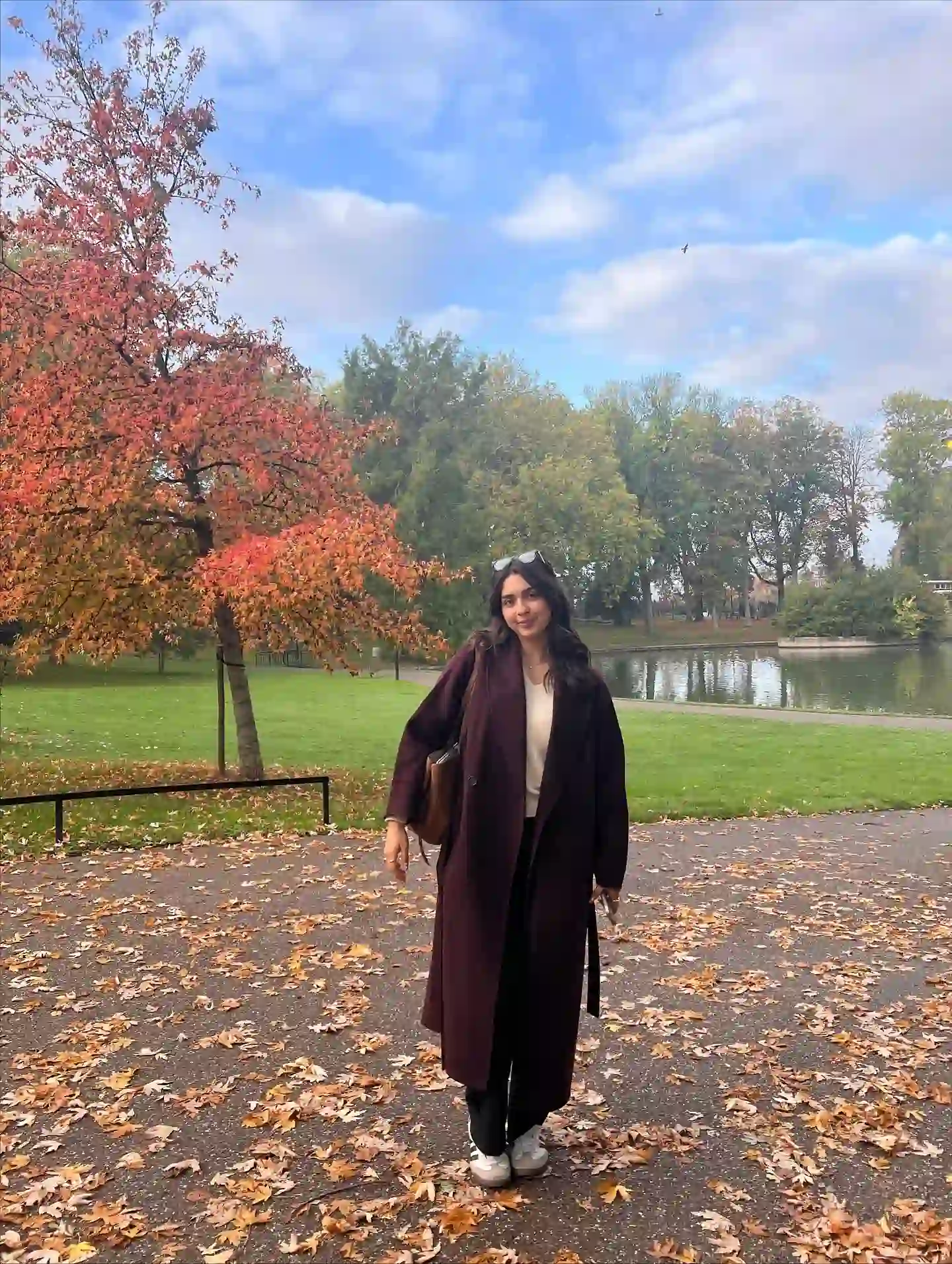 Burgundy Long Coat Over a Cream Knit and Black Trousers
